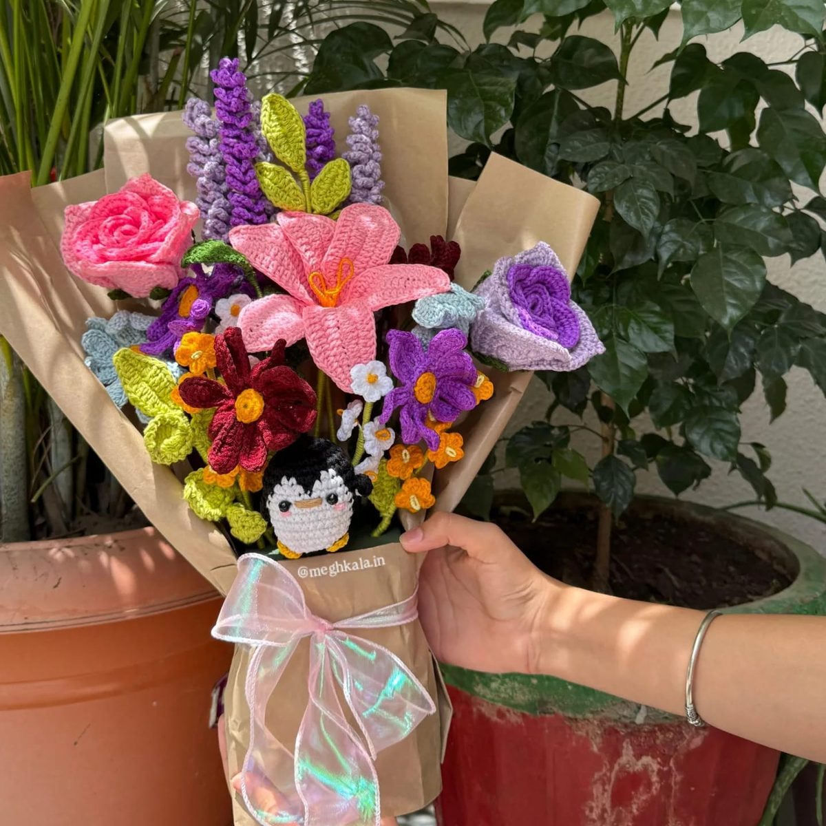 Handmade crochet flower bouquet with a penguin amigurumi, wrapped in kraft paper